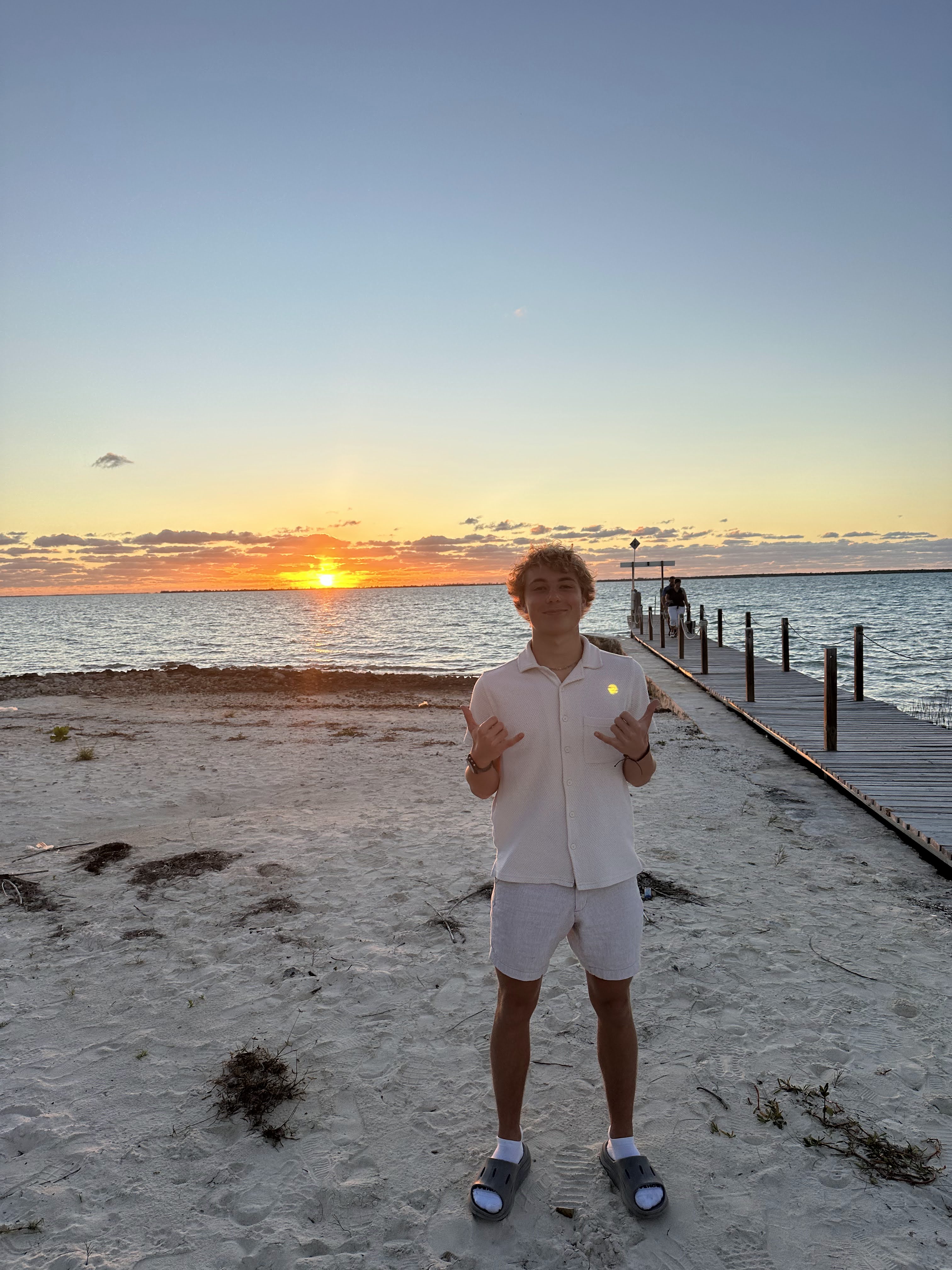 Sam standing by the water at sunset